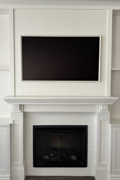 A DIY built-in fireplace and TV wall with an electric insert and frame TV.