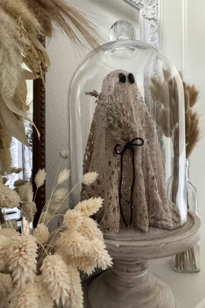 DIY ghost in a cloche holding a bouquet, made from an upcycled sweater