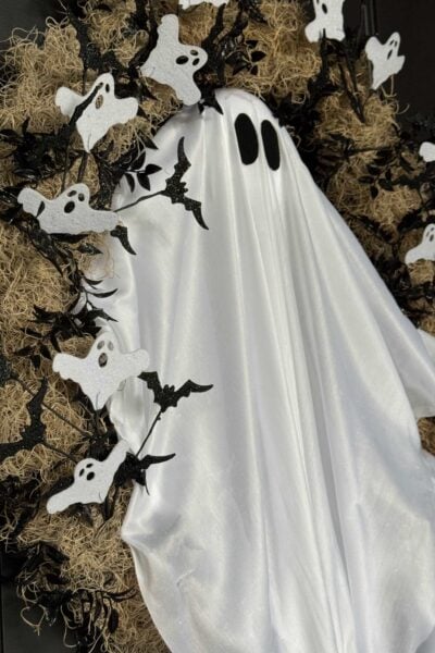 Spanish moss wreath with a large ghost in the center and small bats and ghosts surrounding it.
