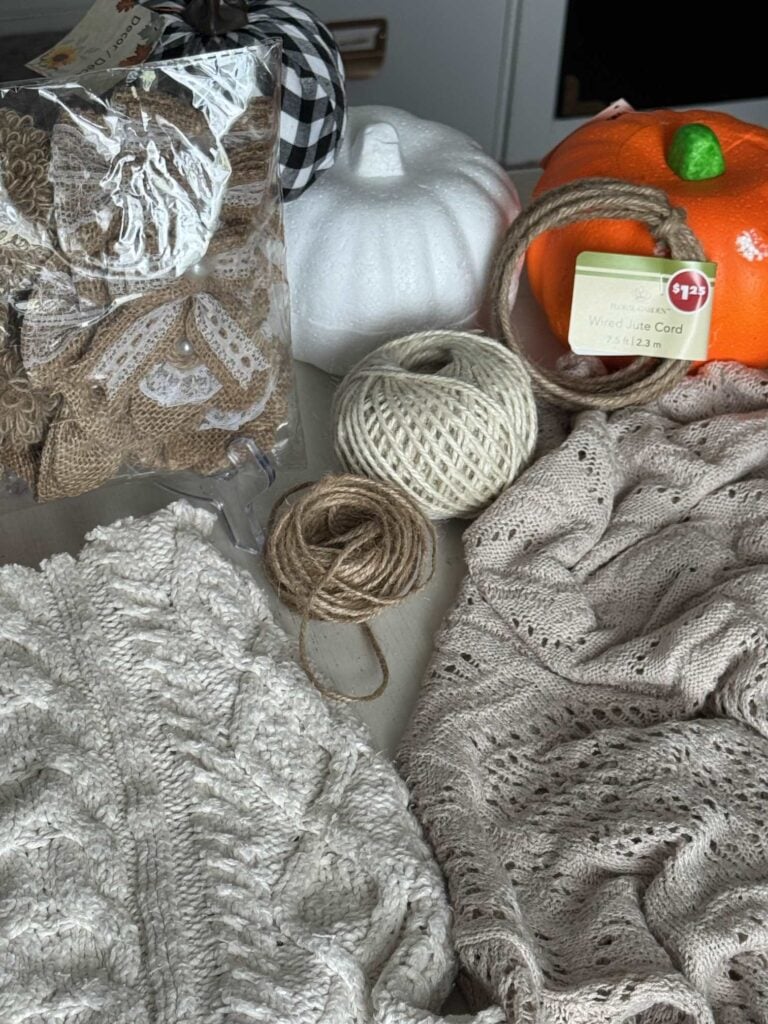 Sweaters, twine, pumpkins, and burlap embellishments needed to make a DIY sweater pumpkin.
