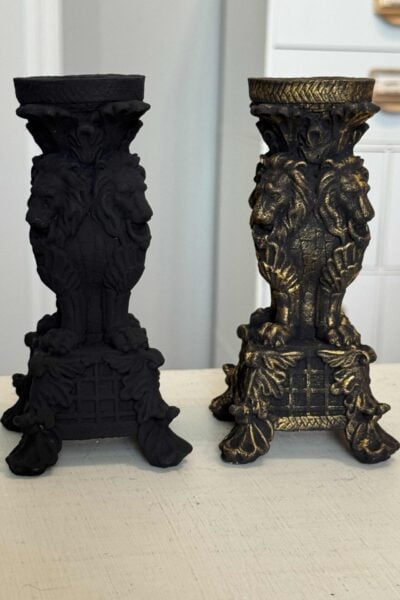 Two black candlesticks, one has gold accents.