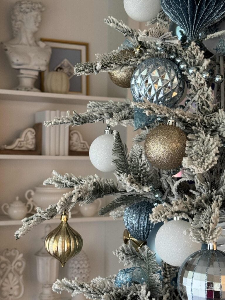 Step eight to decorate a faux flocked Christmas tree: is to hang the rest of your ornaments on the tree.