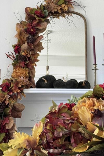 DIY Fall garland with burgundy and gold flowers and leaves, and greenery picks.