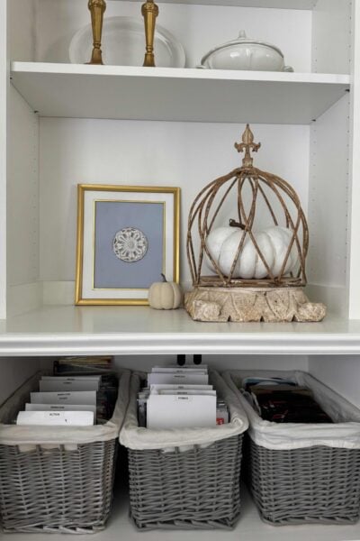 Living room cabinet with DVDS organized in gray baskets.