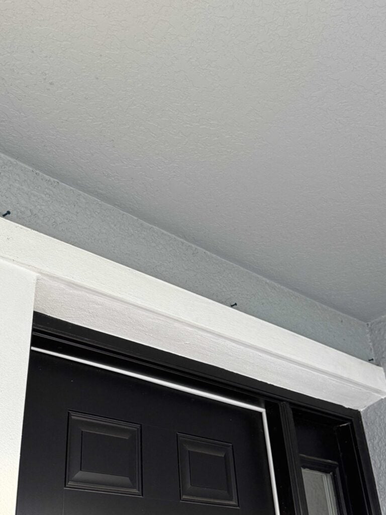 Three masonry screws drilled above a door used to hang Christmas garland. 