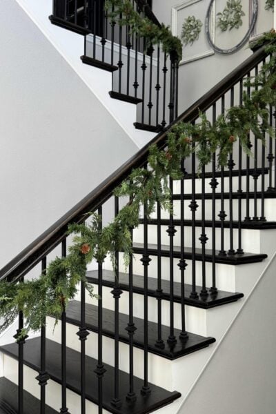 Evergreen Christmas garland hanging on a stair rail.