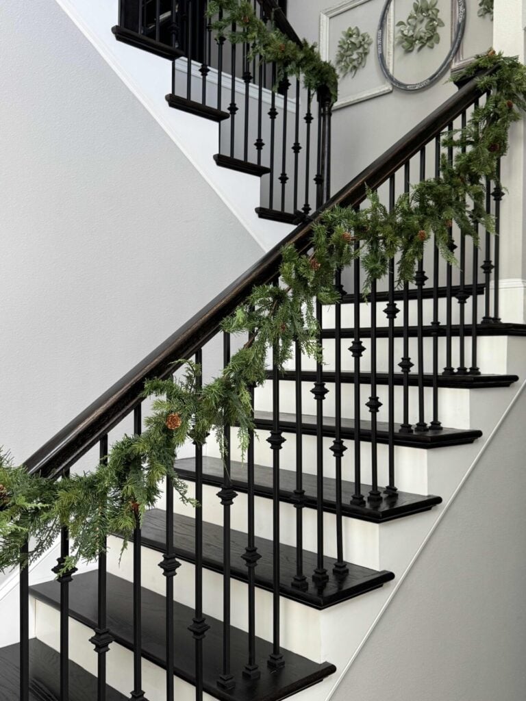 Evergreen garland draped on a stair rail. 