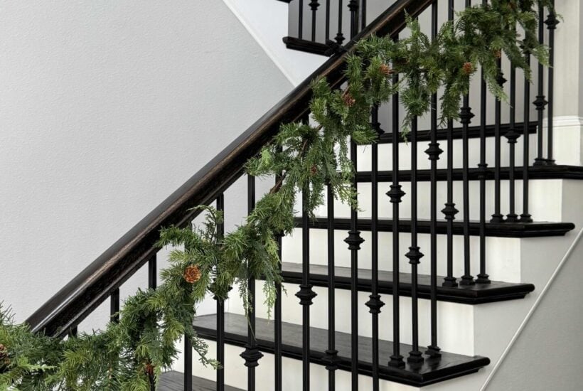 Evergreen Christmas garland hanging on a stair rail.