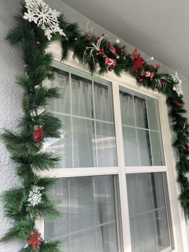 An evergreen garland decorated with red and white ornaments. 