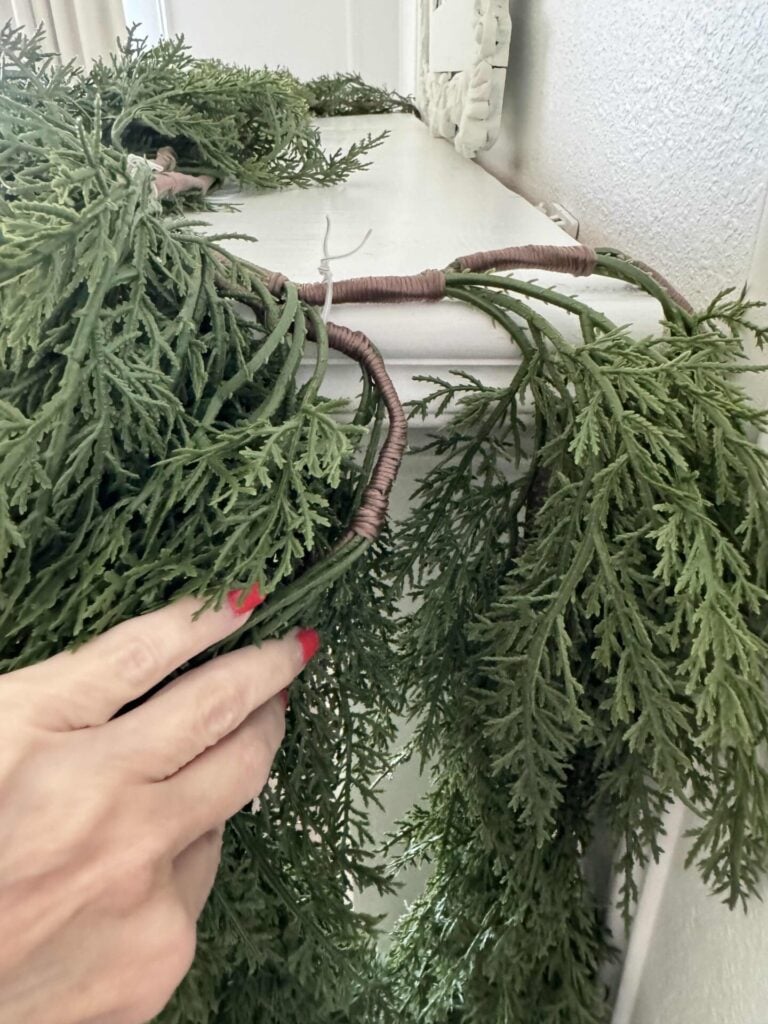 Hang a second Christmas garland on top of the first one and attach them together with clear twist ties. 