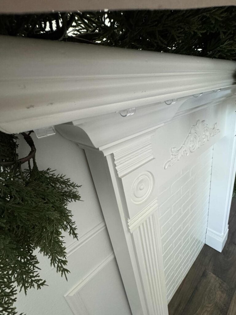 Plastic Command clips that are attached under a mantel. 