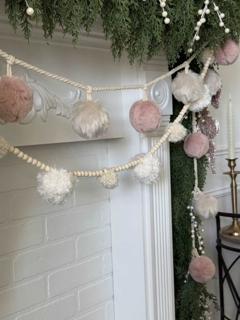 Two pom pom garlands hanging on a mantel. 