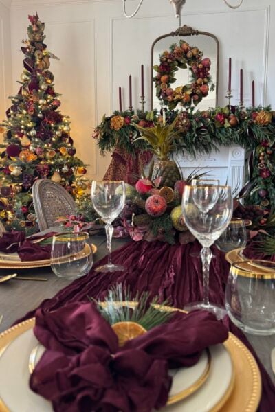 A dining room decorated for Christmas with burgundy and gold.