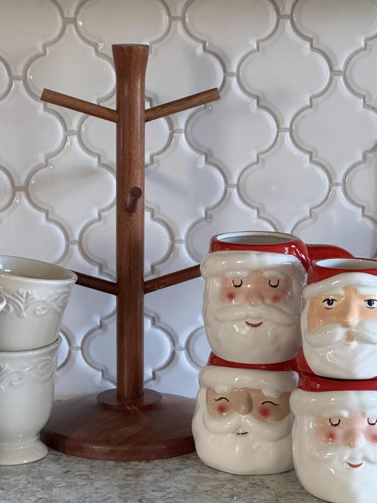A wooden tree mug, four Santa mugs and two off-white coffee cups. 