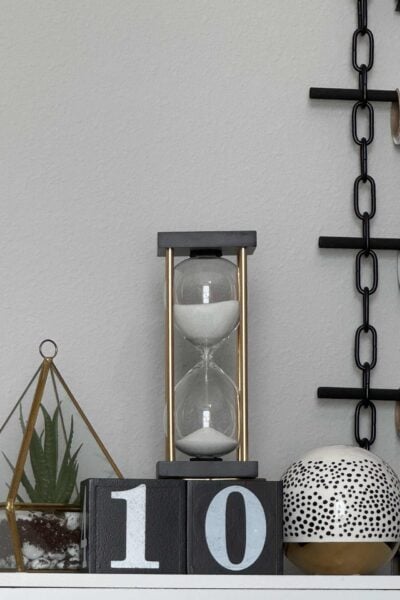 Black blocks with the number ten, an hourglass, plant in terrarium, and decorative orb.