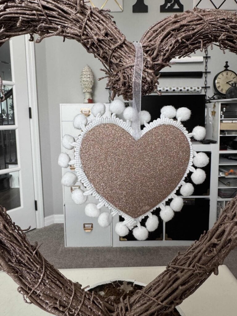 A glitter heart with white pom pom trim. 