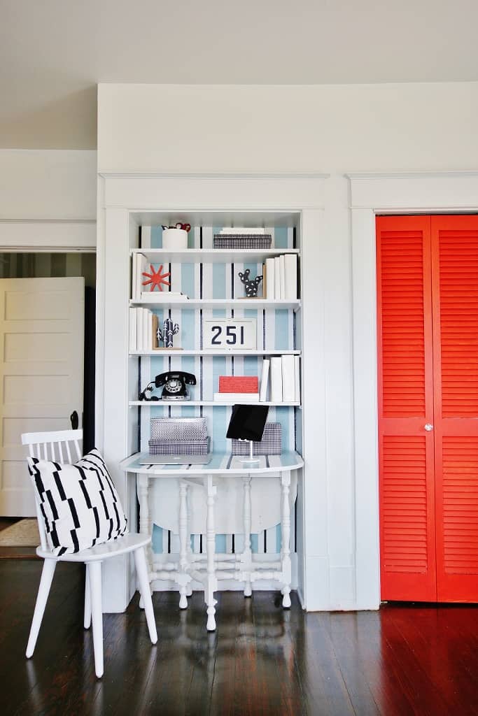 An office created from white built-in shelves.