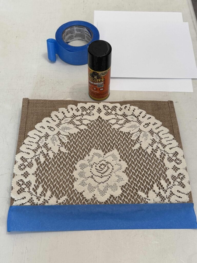 A tote bag with painters tape covering the bottom seam. 