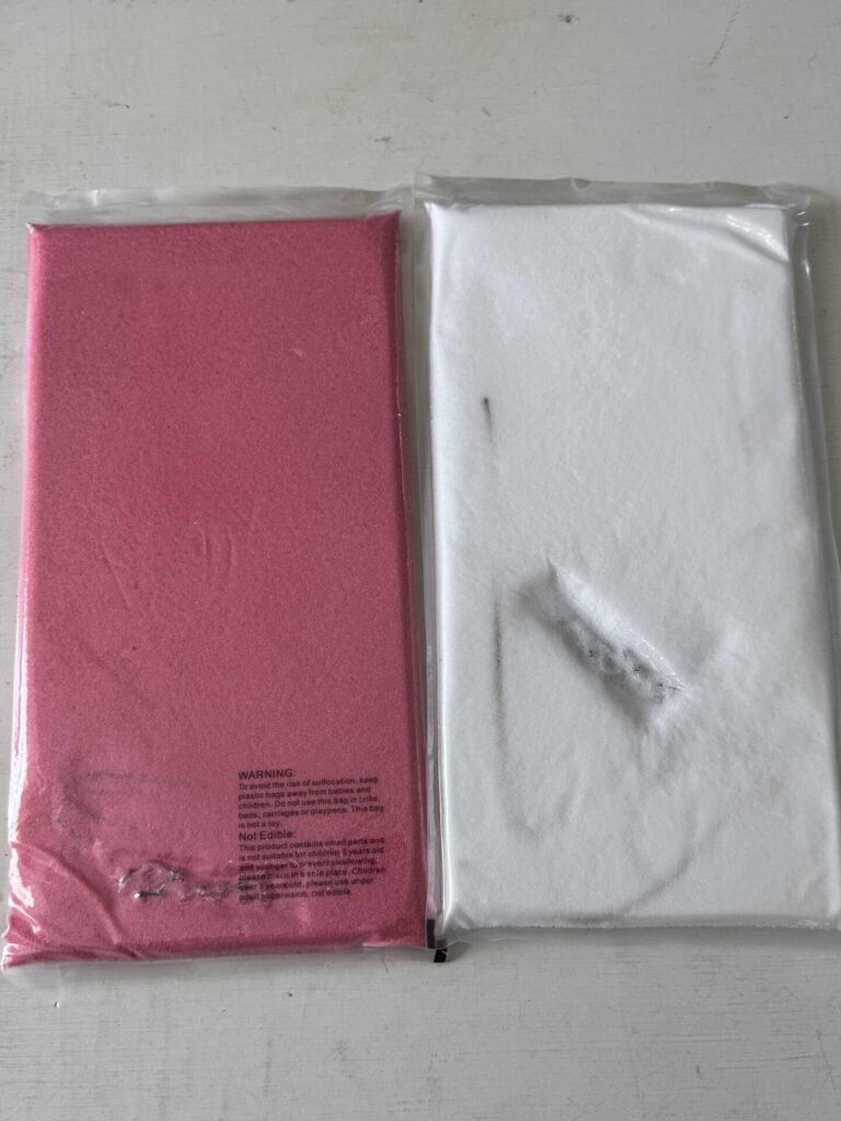 Two sand candle wax kits, one pink and the other white.