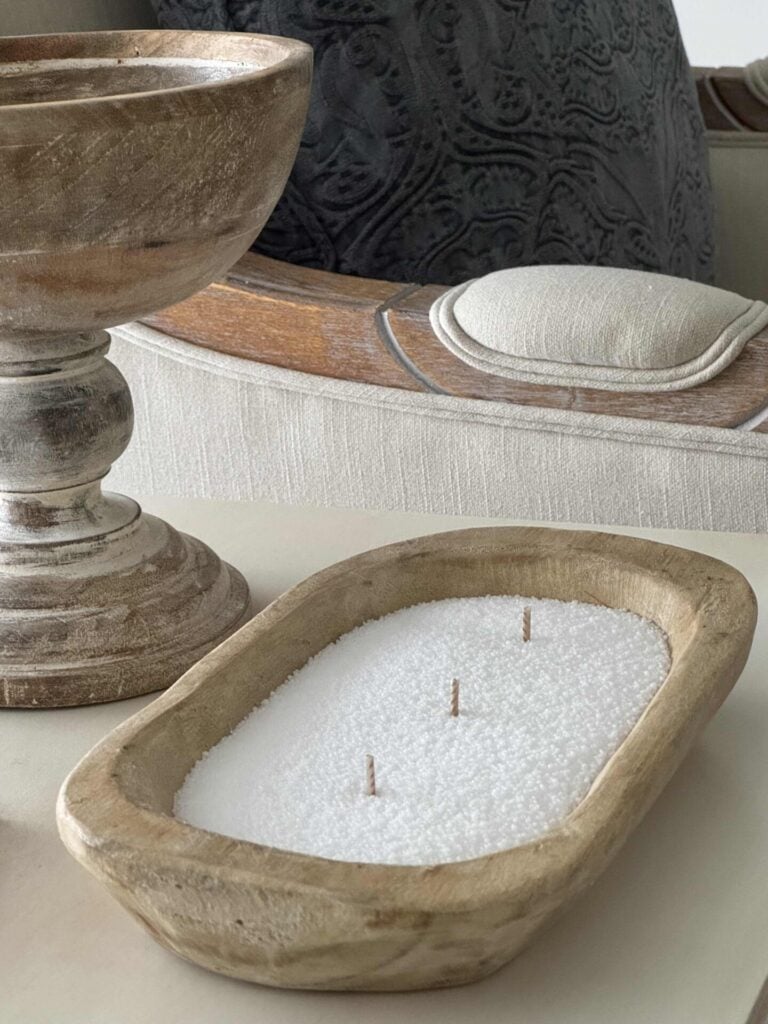 A DIY candle with three wicks in a wooden bowl.