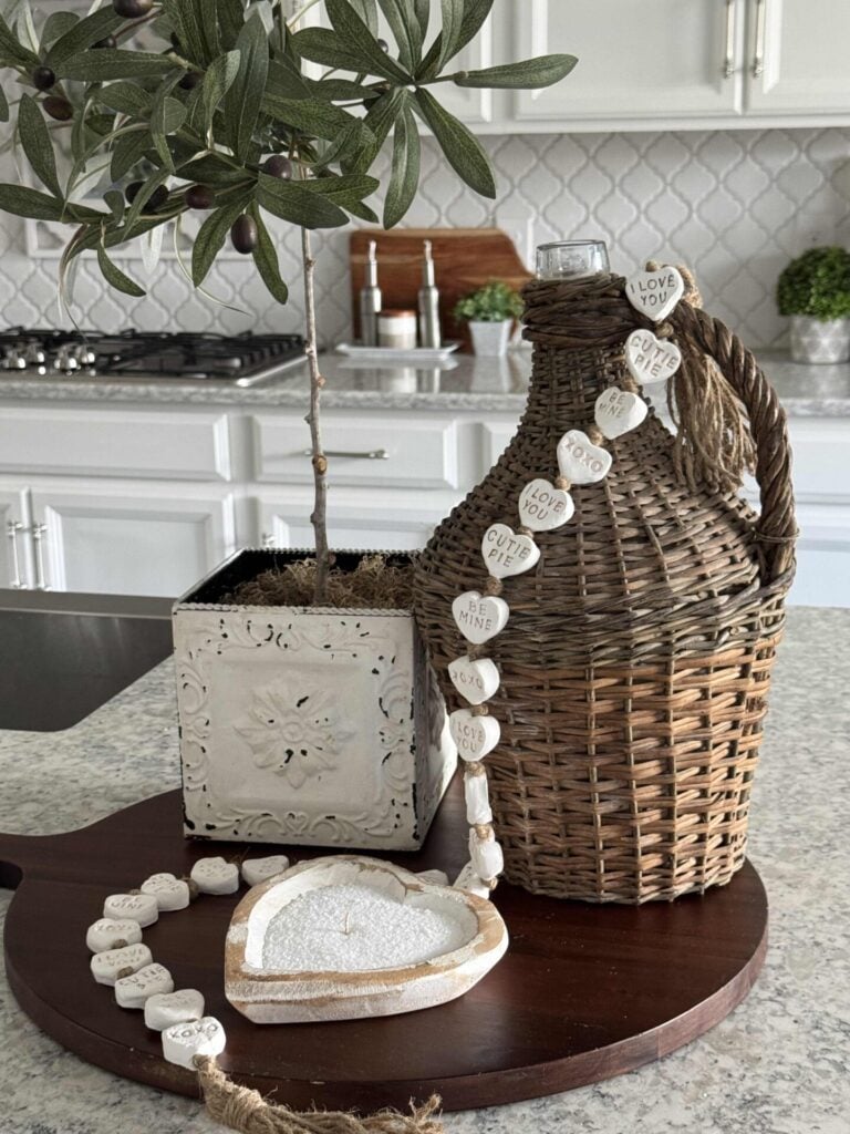 A DIY heart candle in a wood bowl sitting on a kitchen counter.