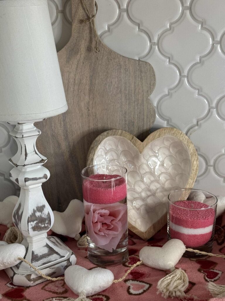 Two DIY candles in a Valentine's vignette.