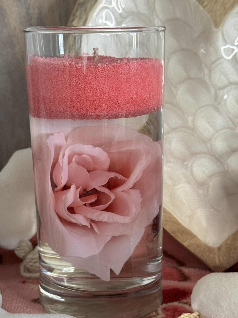 A DIY floating candle with a pink rose.