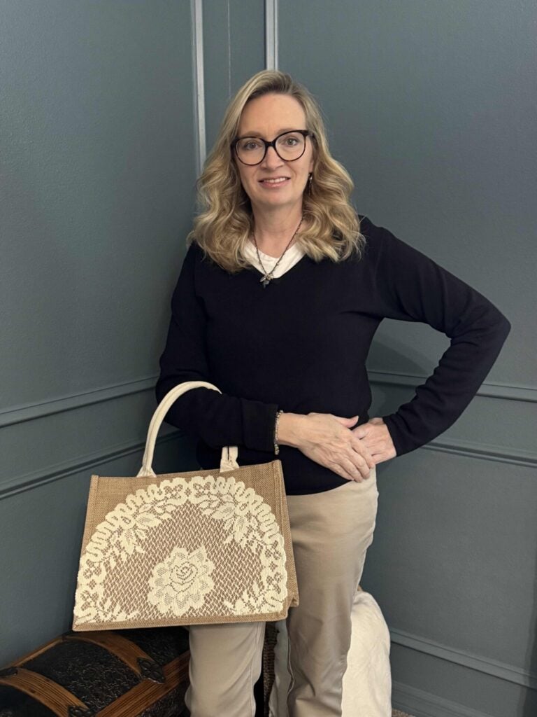 A woman holding a DIY doily tote bag. 