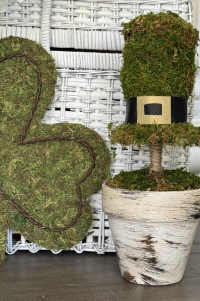 A DIY moss covered leprechaun hat topiary in a painted pot.