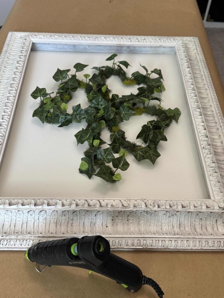 A DIY St. Patrick's shamrock wreath that was hot glued to a white frame. 