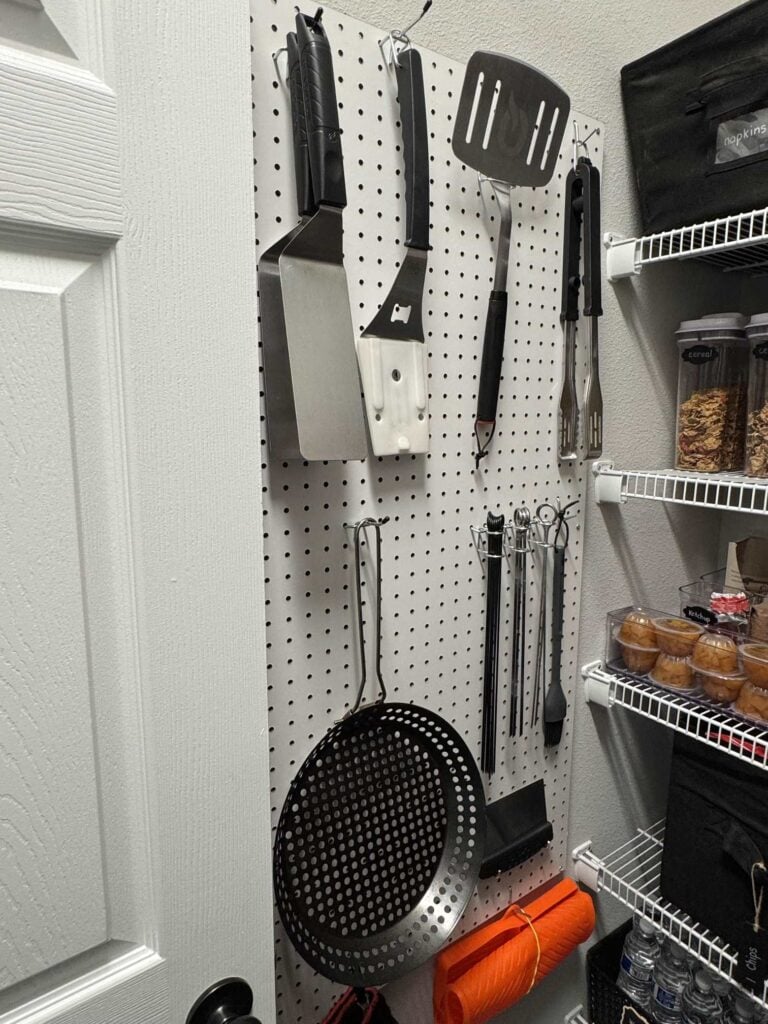 Grill tools displayed on a white pegboard, a practical Spring organization project. 