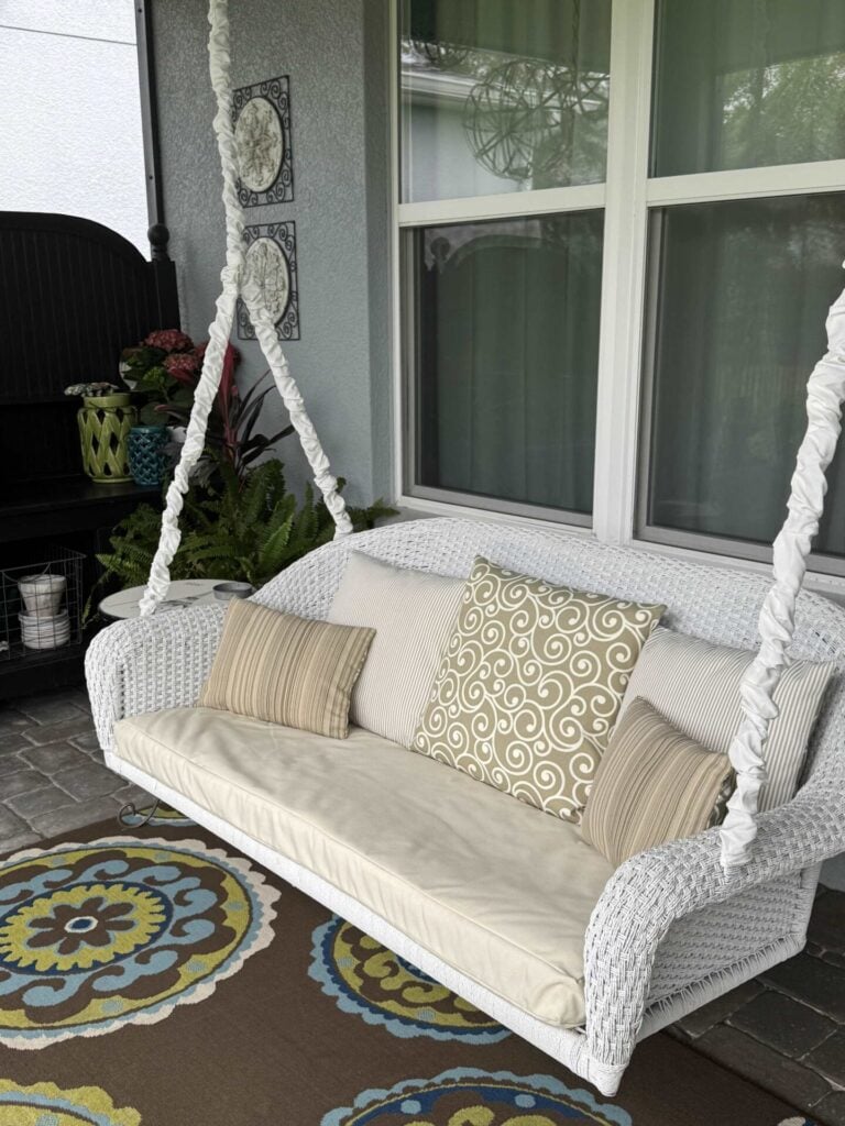 A white wicker swing with cream and tan cushions and white cord covers was a great spring organization project. 