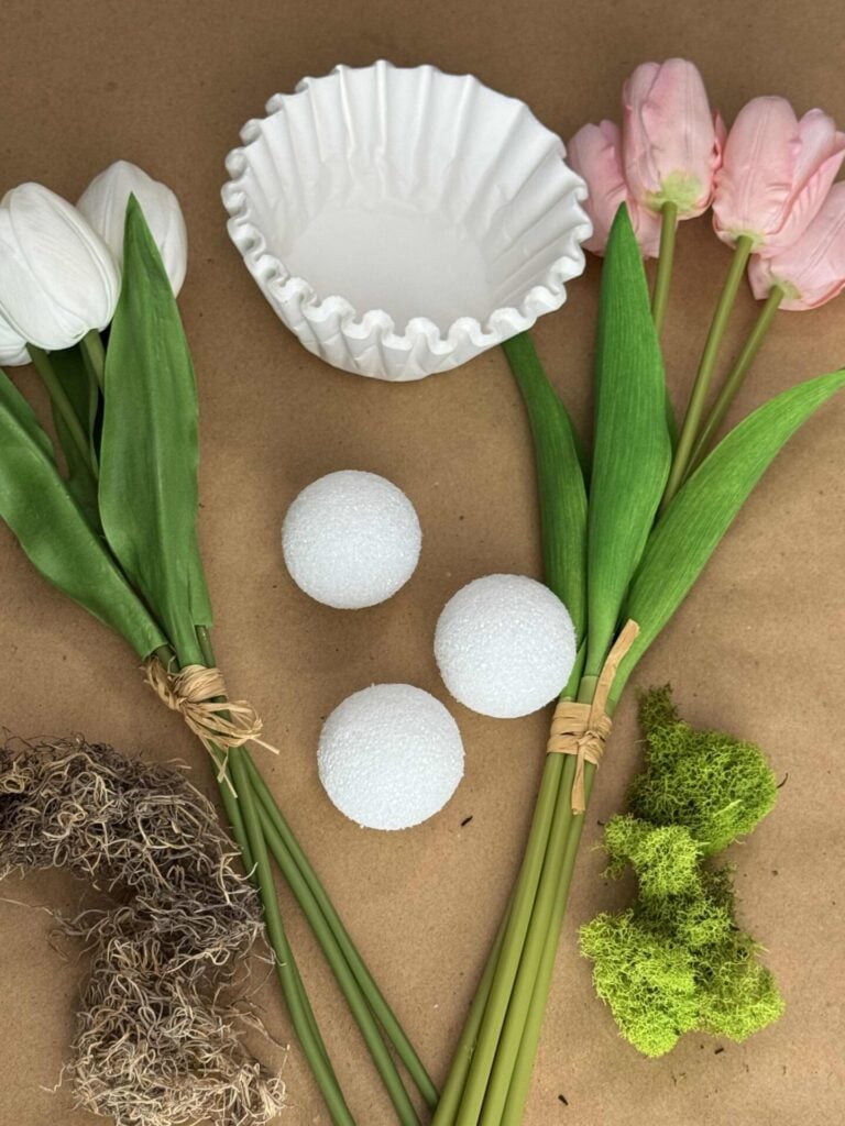 Pink and white faux tulip sets, coffee filters, styrofoam balls, and moss. 