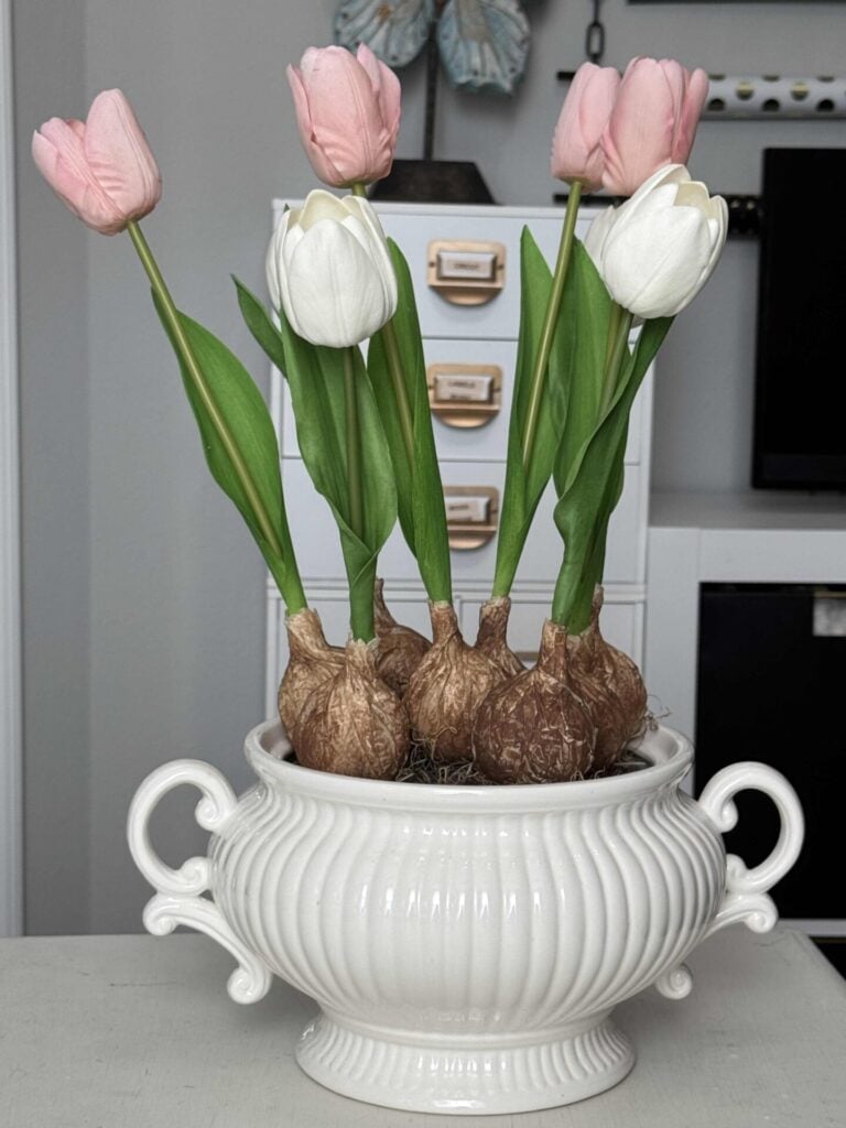 DIY faux tulip bulbs pushed into the styrofoam in a white soup tureen. 