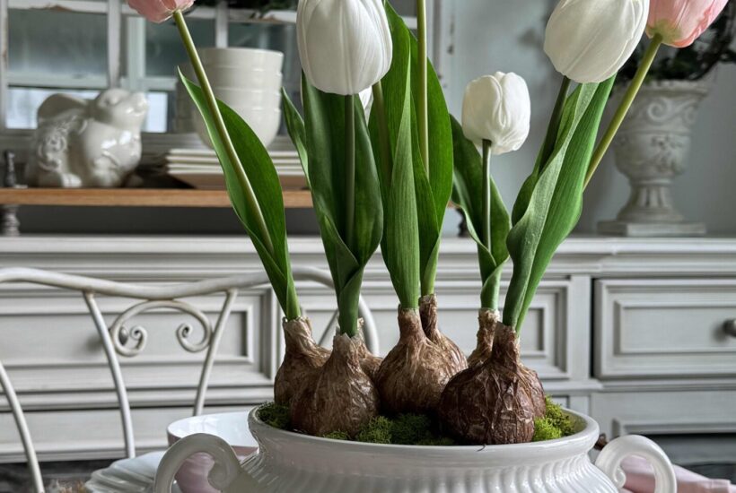 Pink and white faux tulip bulbs arranged in a white soup tureen.