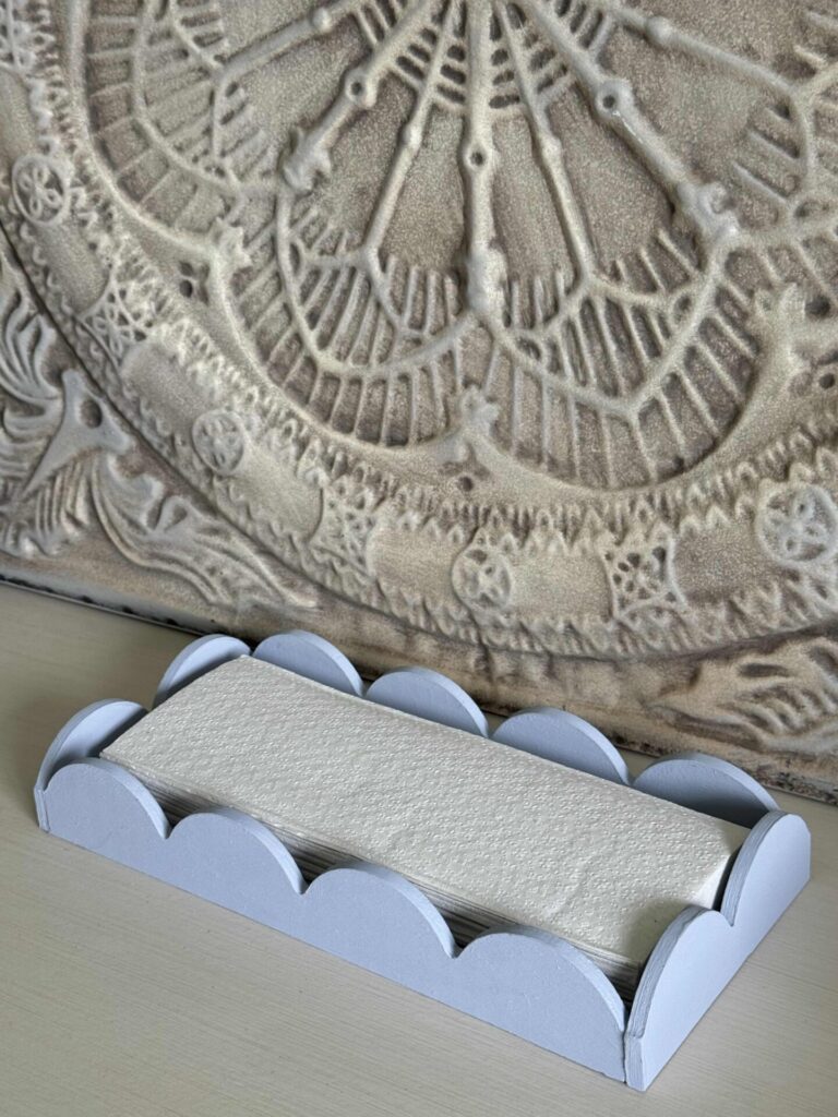 A blue DIY scalloped tray holding paper towels. 