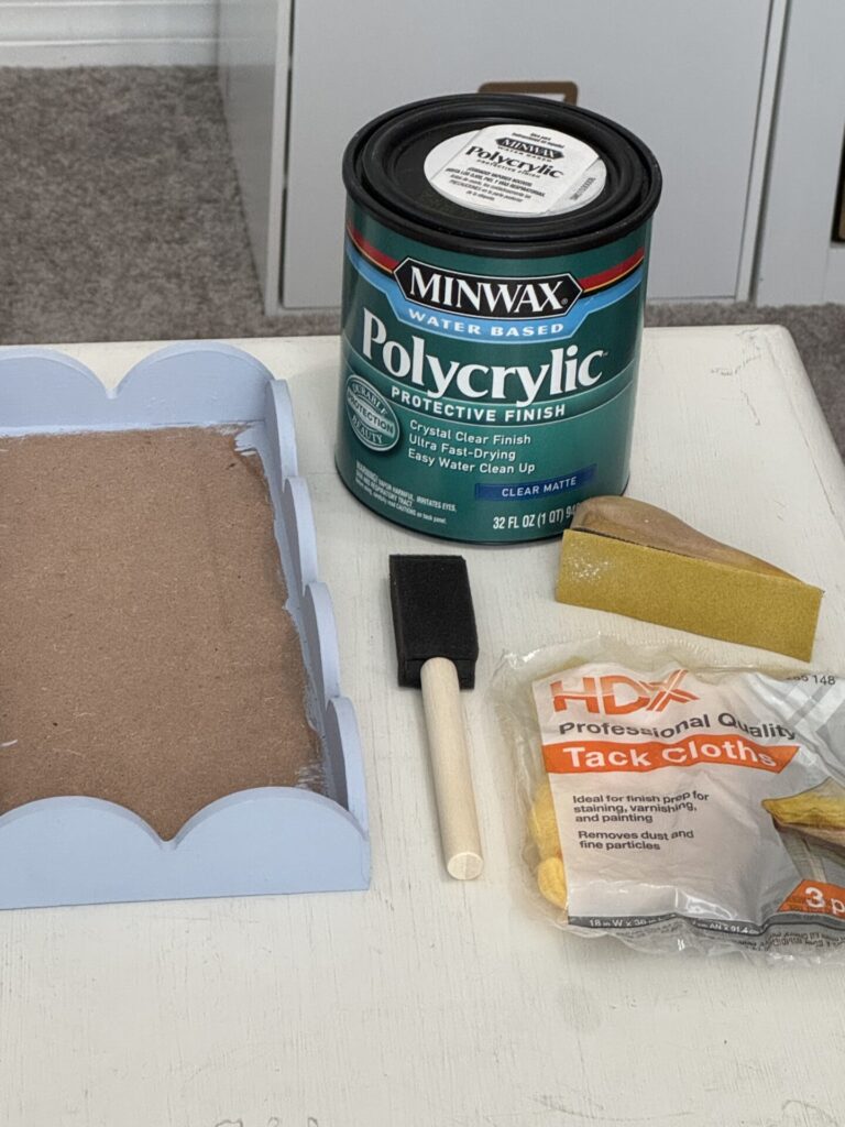 DIY blue tray with can of Polycrylic, sponge brush, tack cloth, and Gator sanding tool.