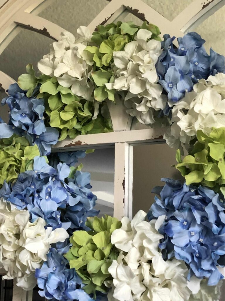 DIY hydrangea wreath made with white, blue, and green blooms.