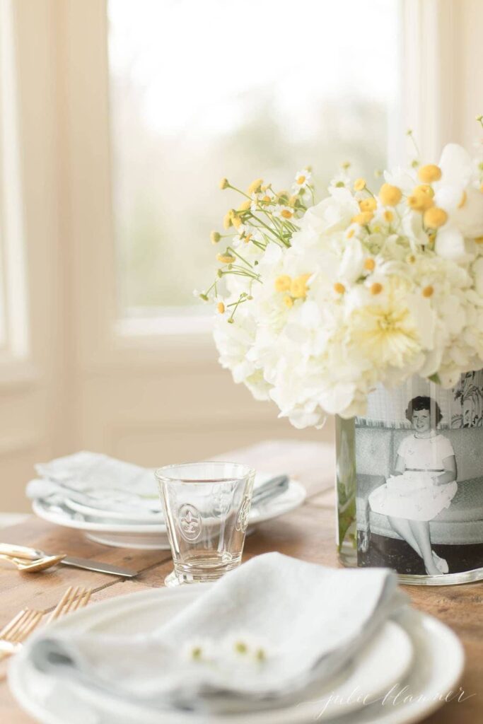 DIY vase with a vintage picture and filled with white and yellow flowers is a perfect Mother's Day gift.