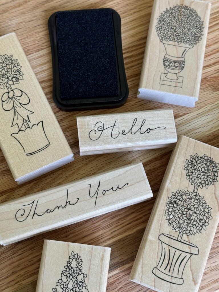 A black ink pad with topiary and greeting stamps.