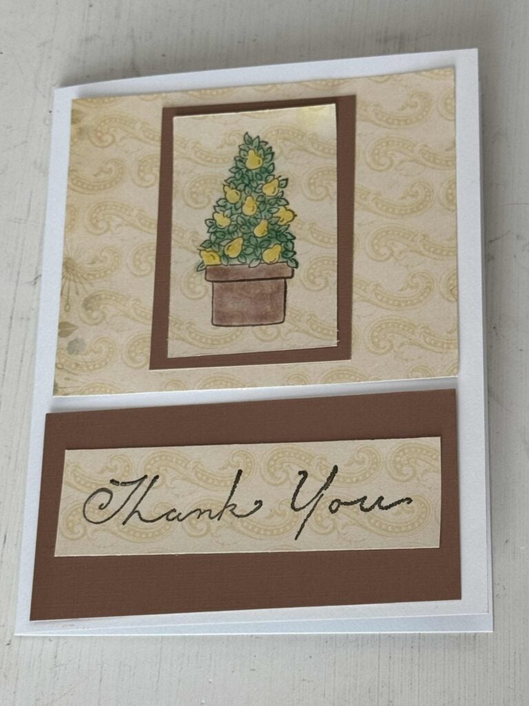 A handmade card with a pear topiary and the words "thank you" stamped on it. 