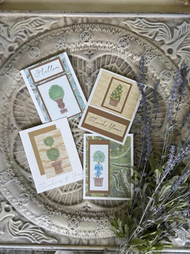 Four handmade cards lying next to lavender. 