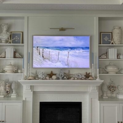 White mantel and built-in shelves decorated for summer with coastal touches.