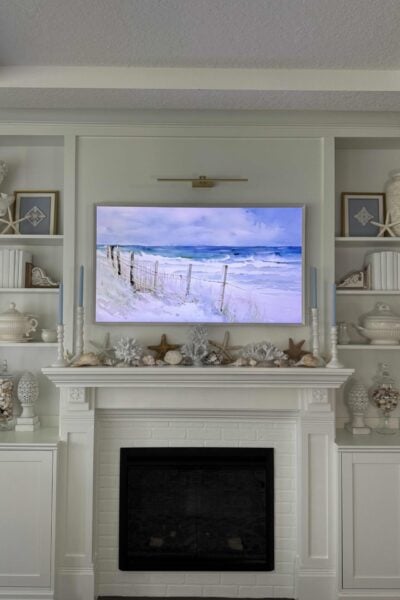 White mantel and built-in shelves decorated for summer with coastal touches.