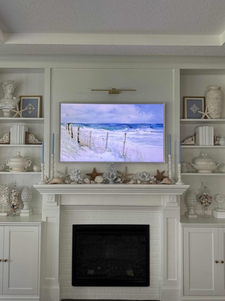 White mantel and built-in shelves decorated for summer with coastal touches.