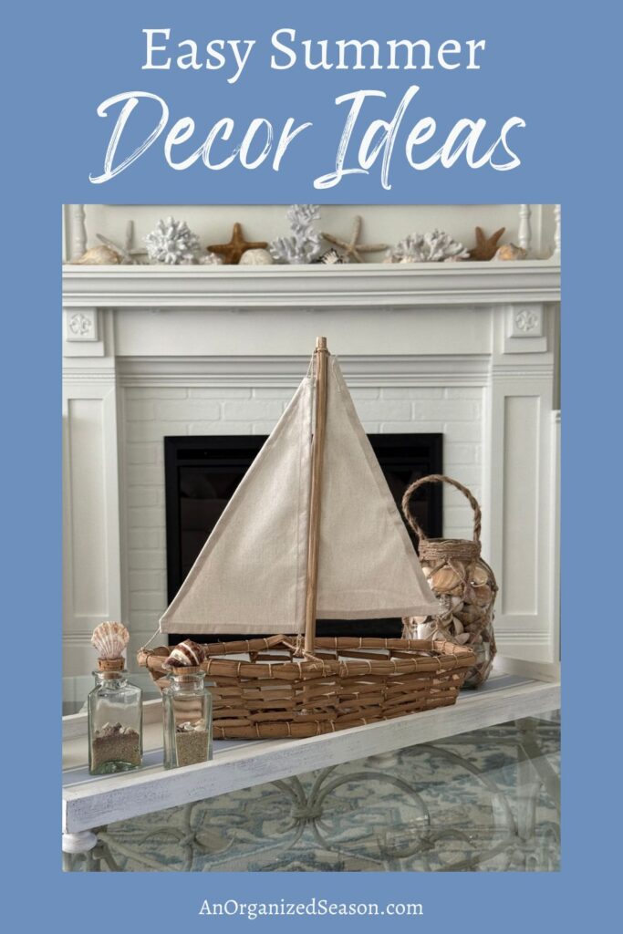 A mantel decorated with coastal-themed items, including a wicker sailboat, glass bottles filled with shells, and starfish, beautifully showcases easy Summer Decor Ideas.