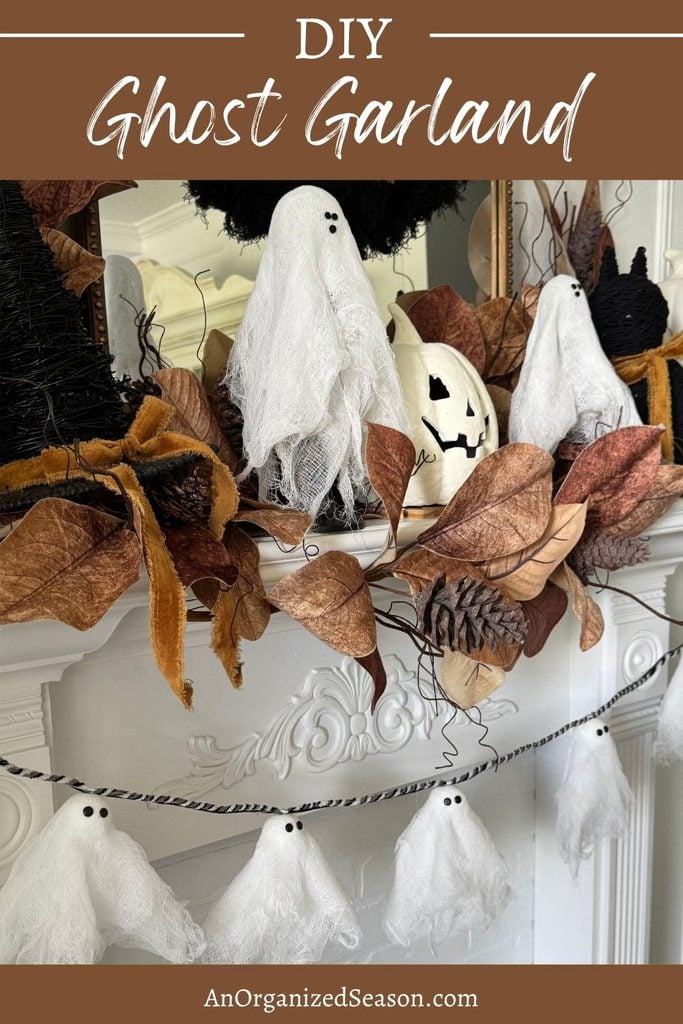 A DIY ghost garland featuring small white fabric ghosts hanging from a string, displayed on a fireplace mantel decorated with autumn leaves and a jack-o-lantern.